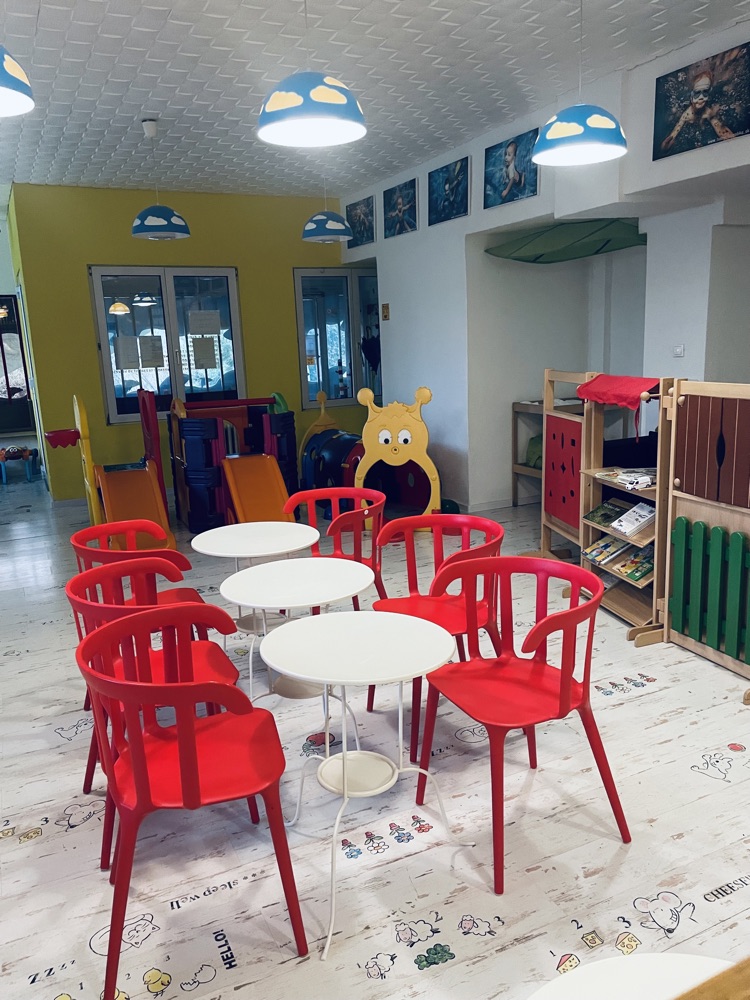 Hracia zostava s toboganom a stoly s červenými stoličkami